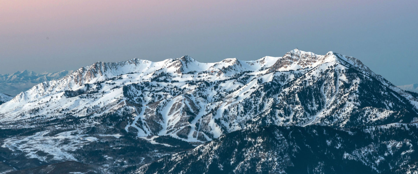 Landscape photo of Snowbasin resort showing ski trails, ridge lines, and multiple peaks.